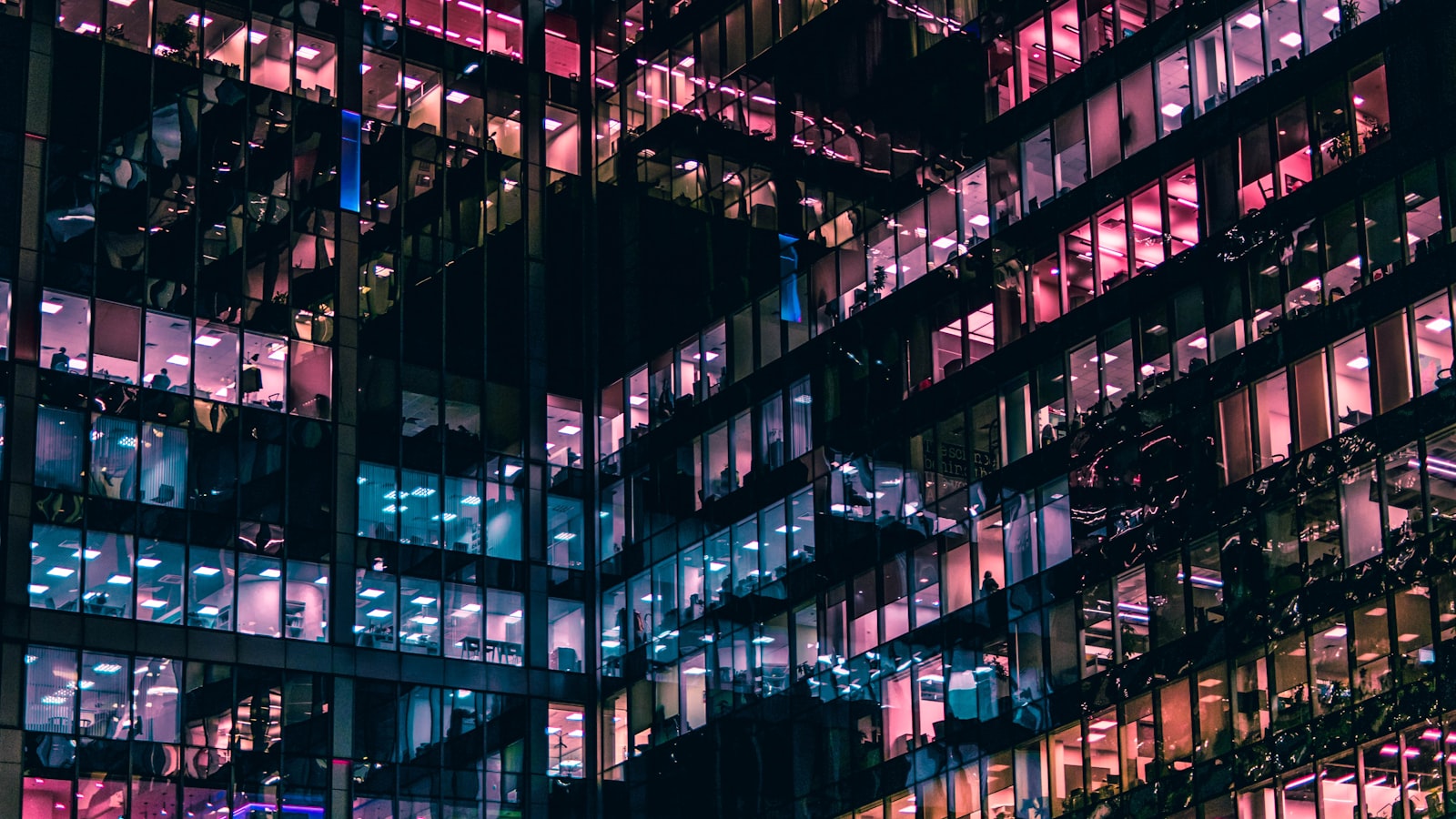 A grid of illuminated windows across a dark skyscraper facade at night