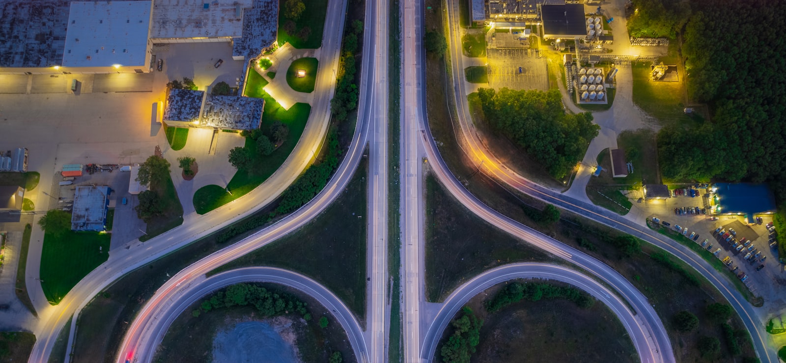 A wide view of an illuminated motorway interchange at night, forming a network of light trails