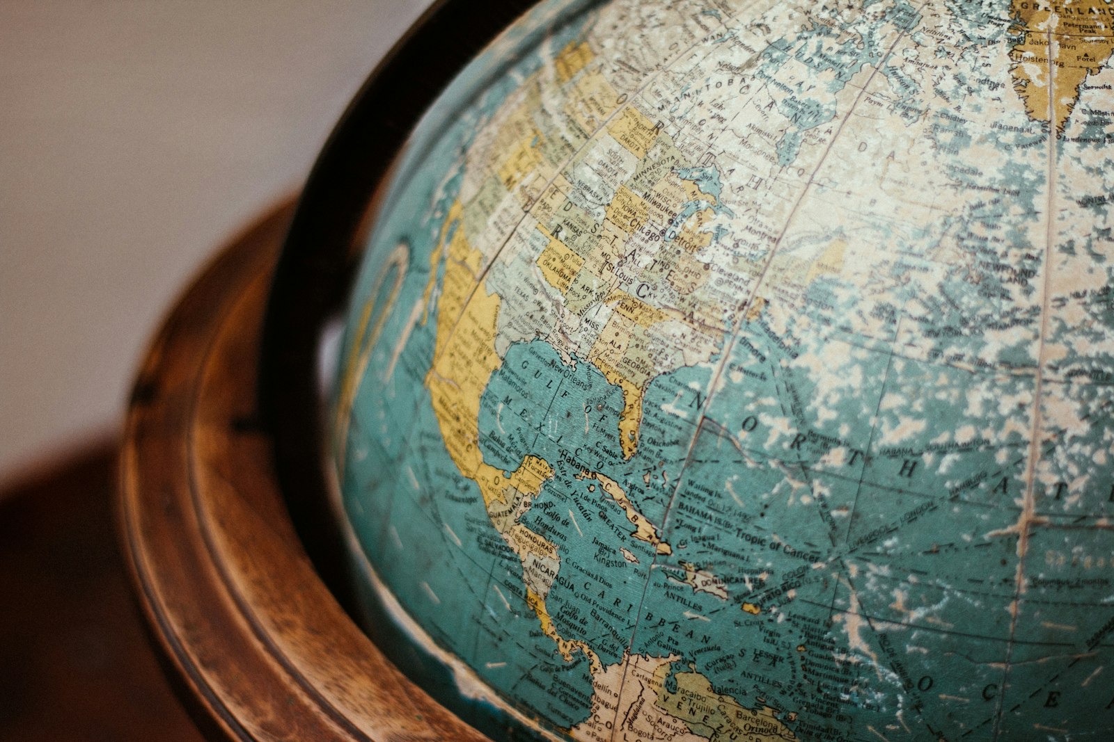 A vintage physical world globe on a wooden stand, North America facing the camera