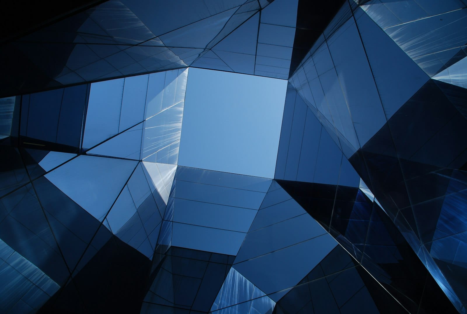 A faceted blue glass building facade forming a geometric grid