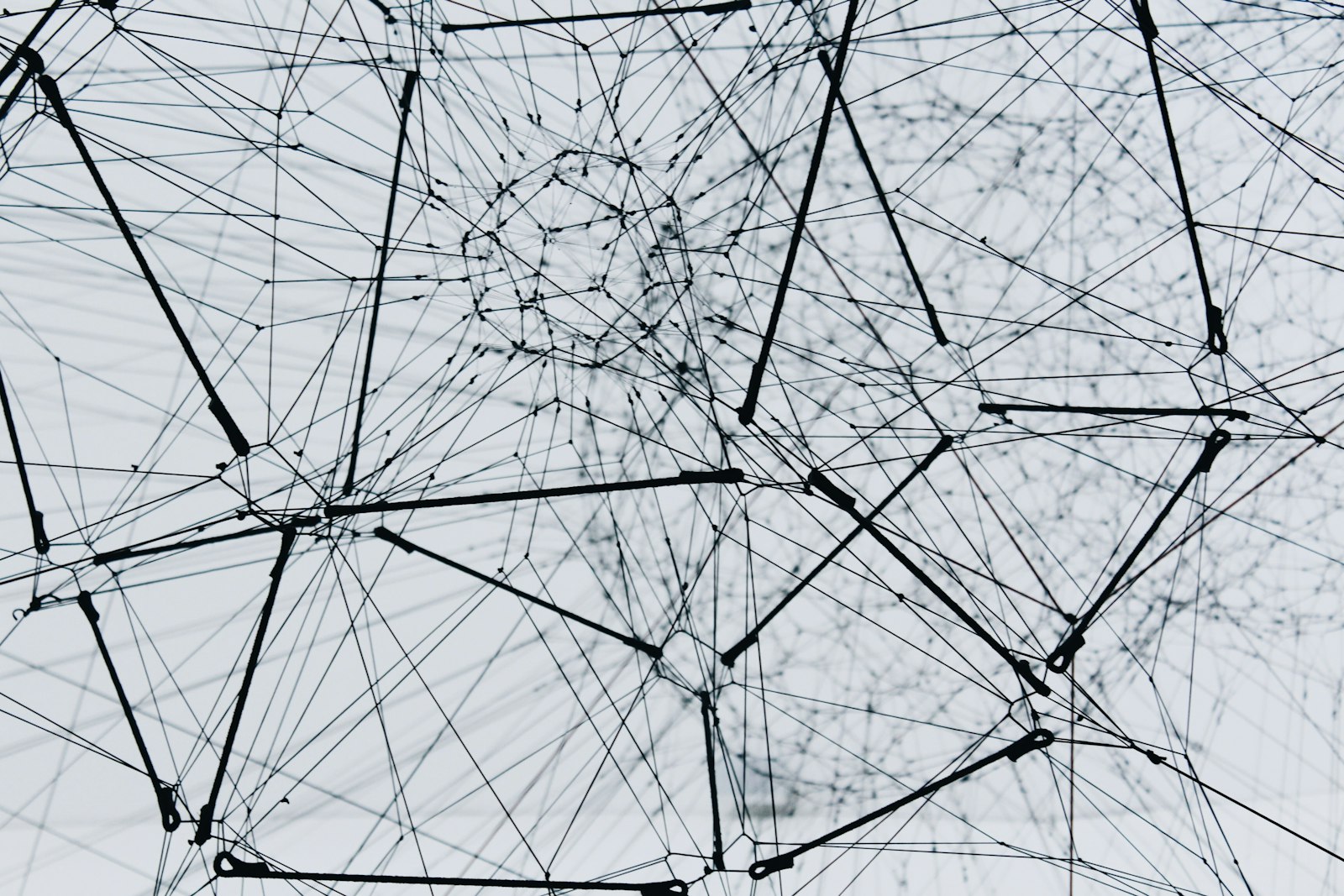 An abstract web of connected black lines and nodes, like a network of dependencies
